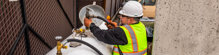Man attaching hose to propane tank